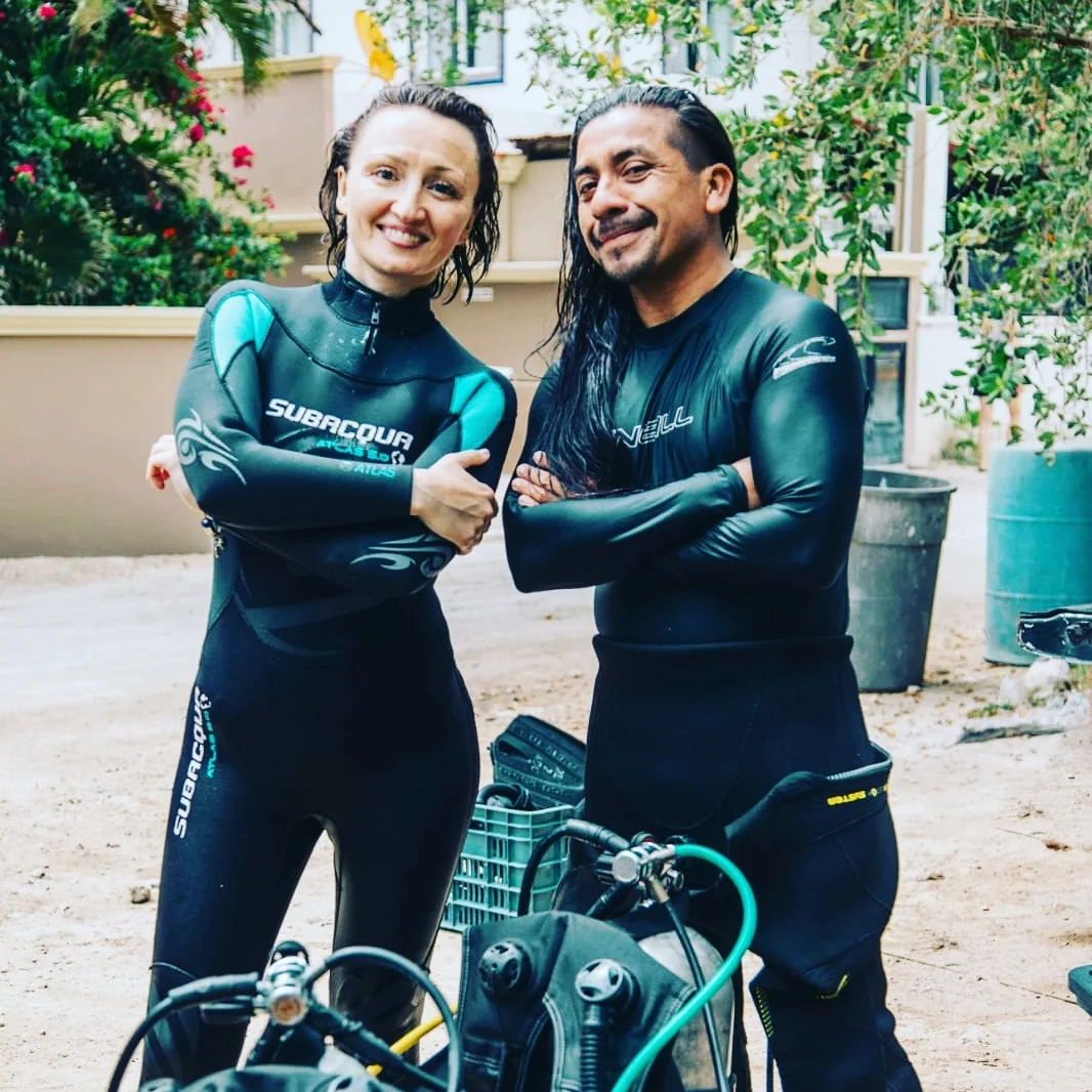 Dive guide checking scuba equipment before entering the water